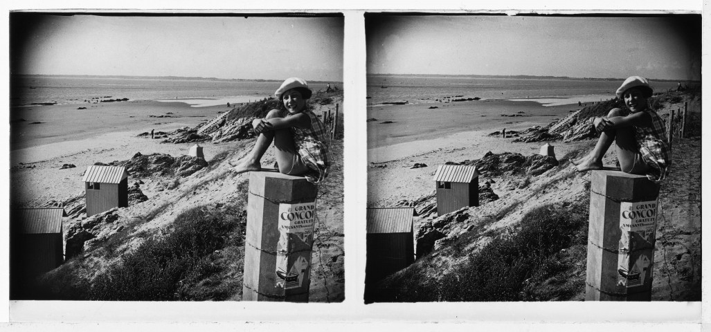 Marguerite assise sur un pilier devant la plage et les cabines