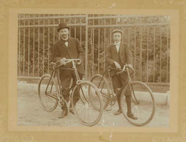 Hommes posant à côté de leur bicyclette