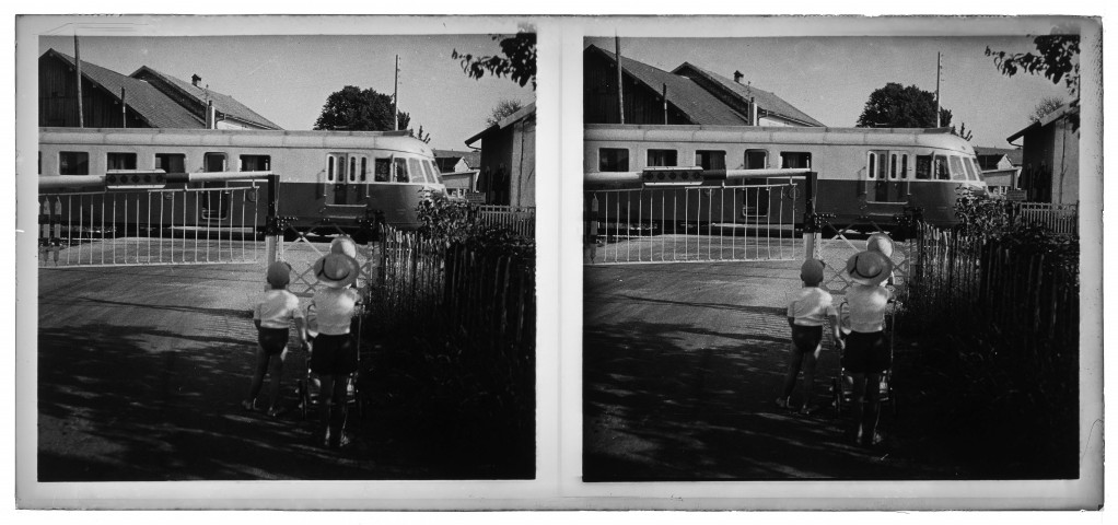 Les enfants regardent le train (autorail) au passage à niveau